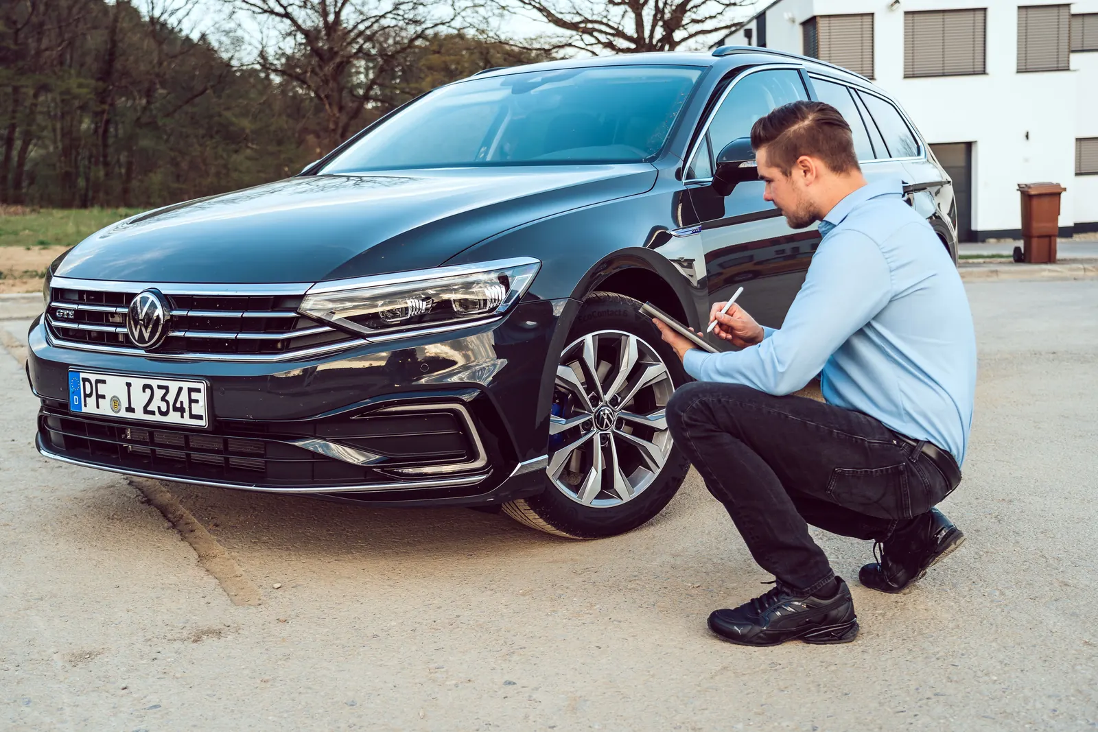 Michael Dorzweiler notiert am Vorderrad eines VW Passat GTE mit E-Kennzeichen Daten auf dem Tablet