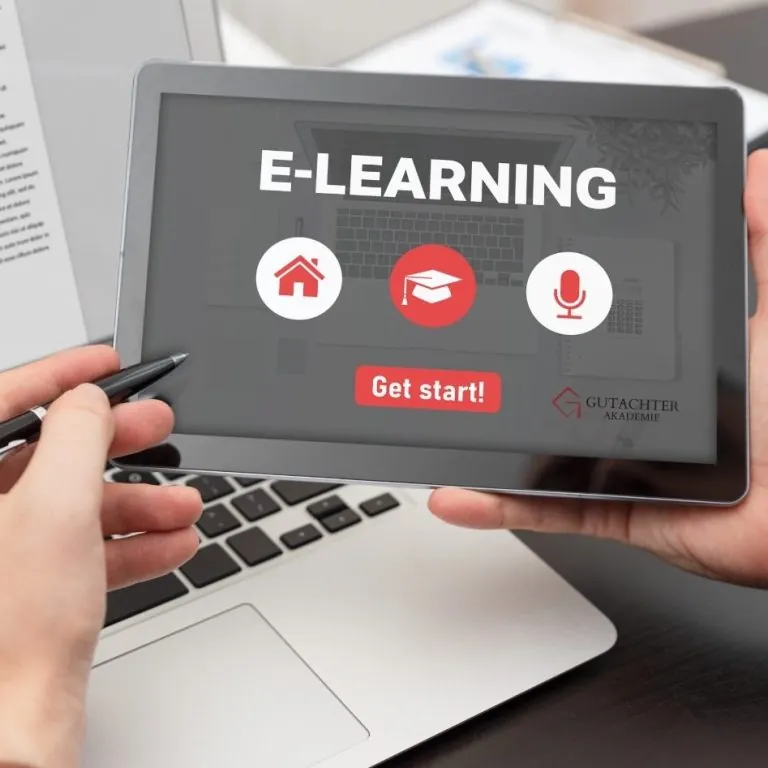 Hände halten ein Tablet mit der E-Learning-Startseite der Gutachter-Akademie über einer Laptop-Tastatur